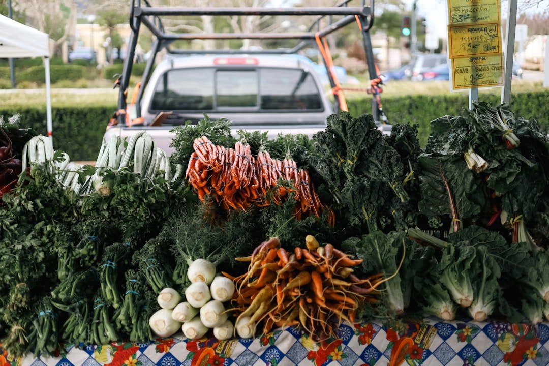Fresh California produce at a farmers market showing whole vegetables with tops and stems intact